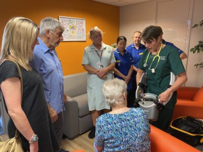 Maureen, Zoe and Robert being shown the LUCAS device 