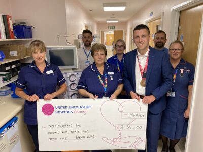 Sergeant Tom Bone presenting the cheque to Sister Lorraine Makin and Sister Jane Meadows, with Matron Siobhan Sodiwala, Deputy Sister Gemma Pullen, Charity Manager Ben Petts and Charity Fundraiser Gary Burr