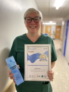 Nicola with her certificate and award at work.